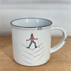 Keramiktasse im Emaille- Look mit einer Schifahrerin im Grätschschritt